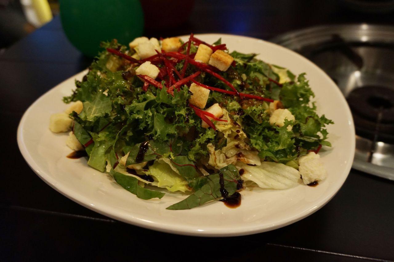 Fresh salad at Hwa Tteok, topped with croutons and a sweet, tangy dressing, complementing the savory Korean dishes.